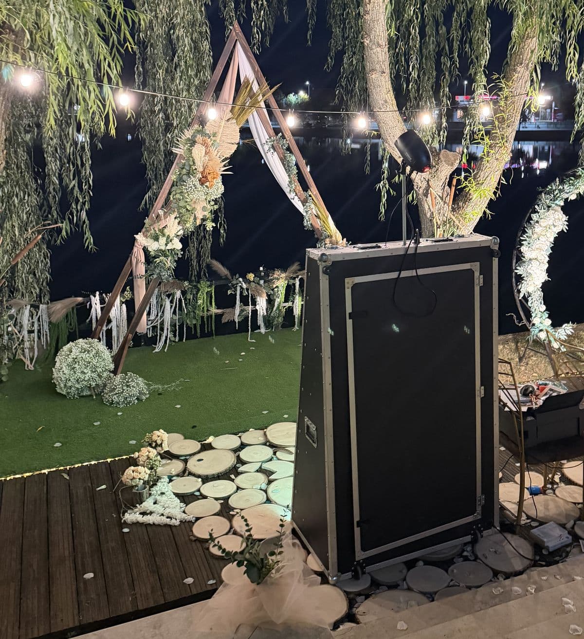Oglinda foto pregătită lângă arcada de ceremonie, sub sălcii și luminițe
