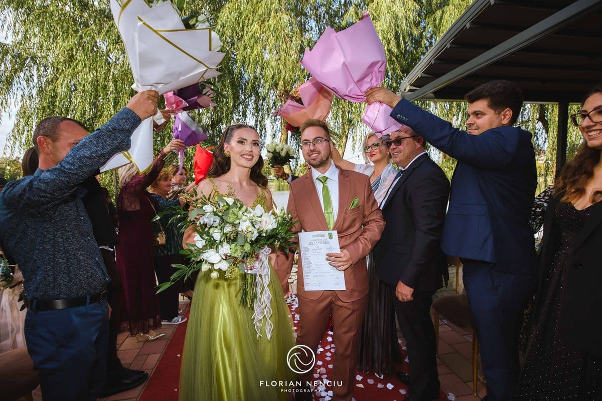 Invitații îi felicită pe miri cu flori după cununie
