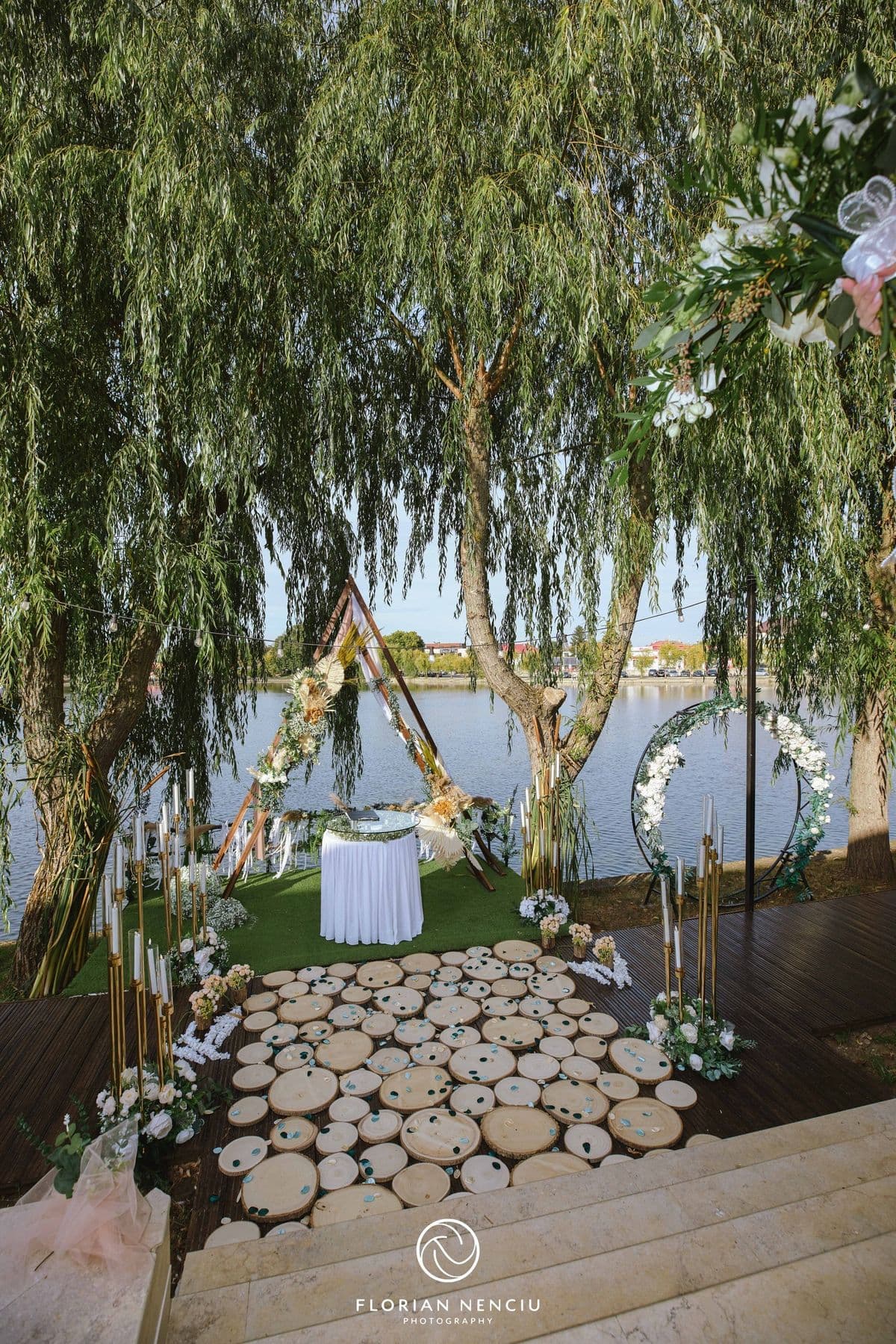 Poteca din felii de lemn care duce spre arcada de ceremonie de pe malul lacului